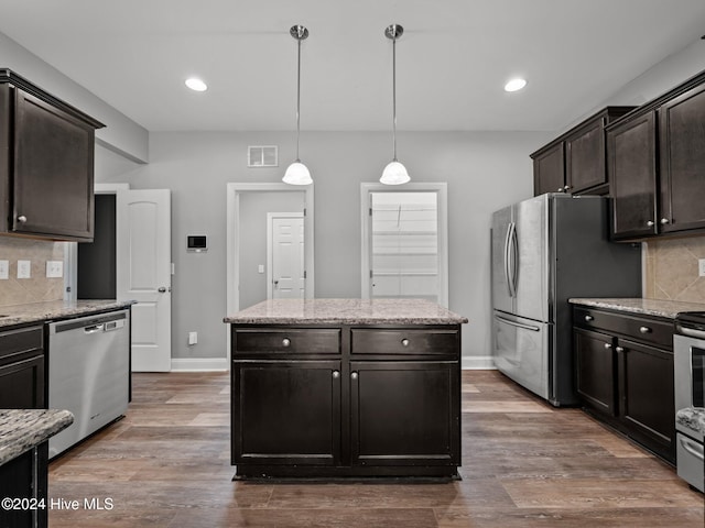 kitchen with backsplash, hanging light fixtures, stainless steel appliances, and wood-type flooring