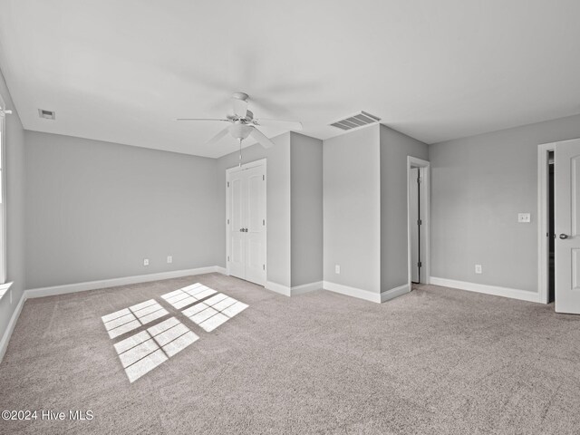unfurnished bedroom featuring baseboards, ceiling fan, visible vents, and carpet