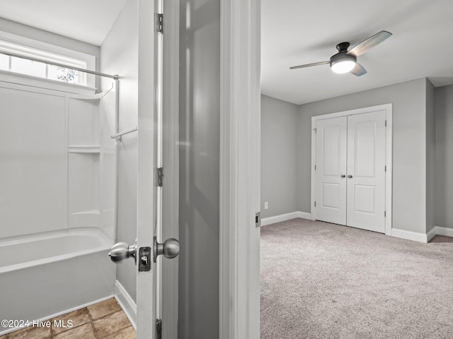 bathroom featuring washtub / shower combination and ceiling fan