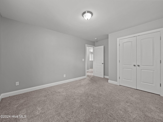 unfurnished bedroom featuring carpet flooring, a closet, and baseboards