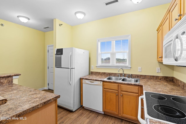 kitchen with white appliances, sink, and light hardwood / wood-style flooring