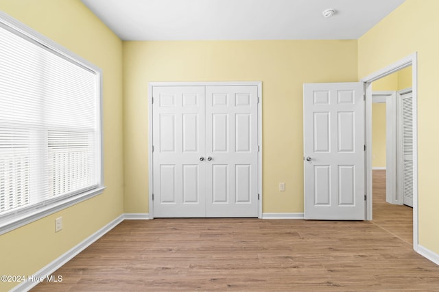 unfurnished bedroom featuring light hardwood / wood-style floors and a closet