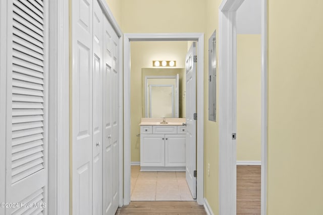 hallway with sink and light wood-type flooring