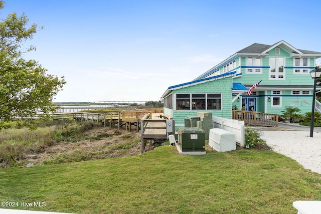 exterior space featuring a lawn, central air condition unit, and a deck