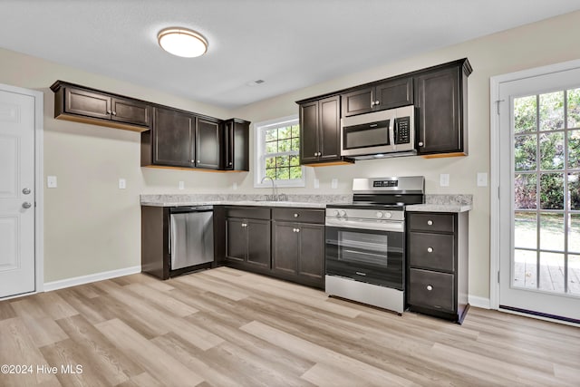 kitchen featuring a wealth of natural light, sink, appliances with stainless steel finishes, and light wood-type flooring