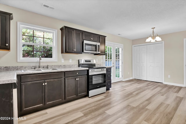 kitchen with a chandelier, appliances with stainless steel finishes, sink, and plenty of natural light