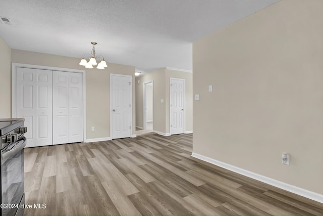 1912 Paulette Rd, Morehead City, NC 28557 - unfurnished dining area with wood finished floors, baseboards, a chandelier, and a textured ceiling