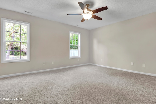 spare room with carpet, a textured ceiling, and ceiling fan