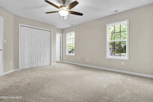 1912 Paulette Rd, Morehead City, NC 28557 - unfurnished bedroom featuring carpet, baseboards, a textured ceiling, a closet, and a ceiling fan