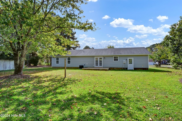 rear view of property with french doors and a yard