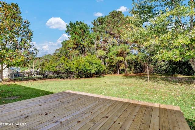 wooden deck featuring a lawn