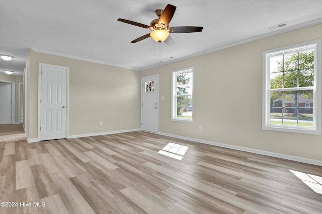 empty room featuring ornamental molding, light hardwood / wood-style flooring, a textured ceiling, and ceiling fan