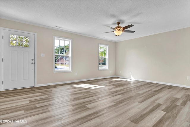 foyer entrance featuring light hardwood / wood-style flooring, a textured ceiling, and a wealth of natural light