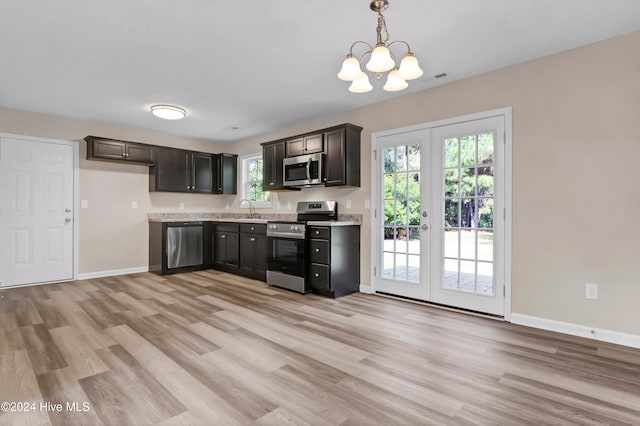 kitchen with light wood-type flooring, appliances with stainless steel finishes, and plenty of natural light