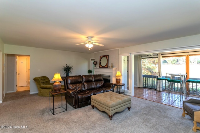 carpeted living area with a ceiling fan, baseboards, and a fireplace