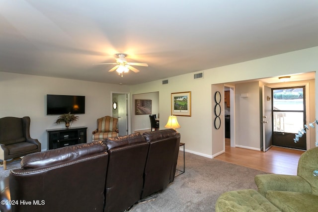 living area with visible vents, baseboards, a ceiling fan, and carpet floors