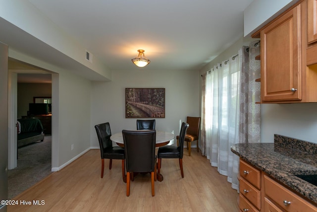 dining room with baseboards, light wood-style flooring, and visible vents