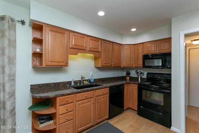 kitchen with a sink, light wood finished floors, open shelves, and black appliances