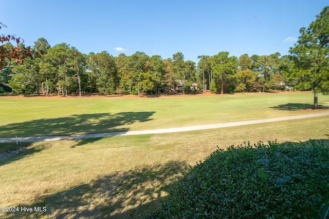 surrounding community featuring a lawn and golf course view