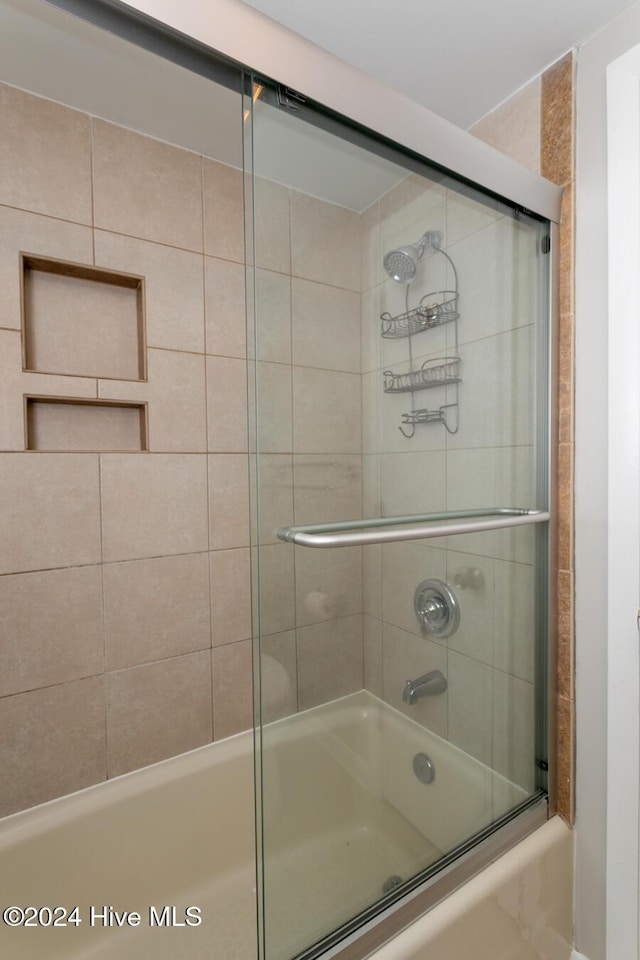 full bathroom with bath / shower combo with glass door