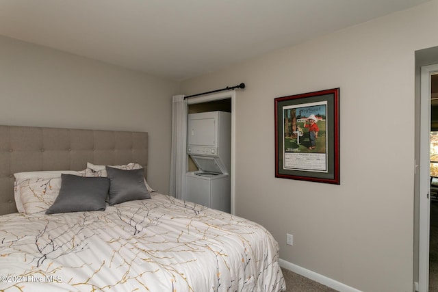 carpeted bedroom featuring stacked washer and dryer and baseboards