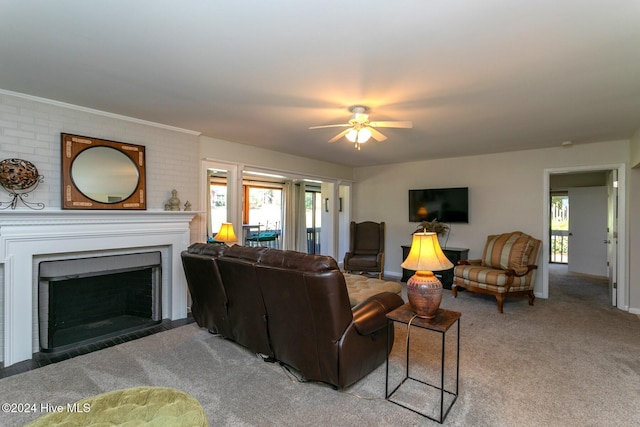 living area featuring light colored carpet, baseboards, a ceiling fan, and a brick fireplace