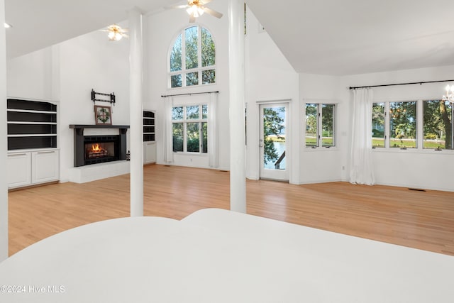 unfurnished bedroom featuring ceiling fan, high vaulted ceiling, and light hardwood / wood-style flooring