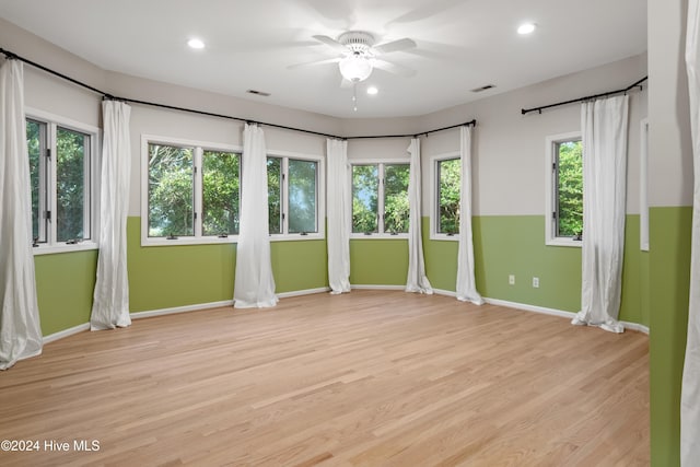 spare room with ceiling fan and light wood-type flooring