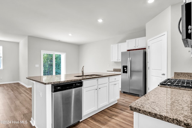 kitchen featuring a kitchen island with sink, stainless steel appliances, sink, white cabinets, and light hardwood / wood-style floors