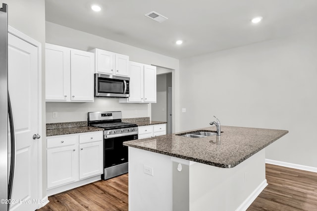 kitchen with appliances with stainless steel finishes, white cabinets, a kitchen island with sink, and wood-type flooring