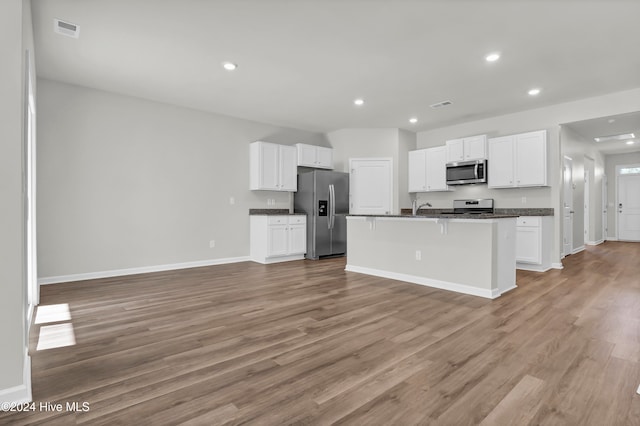 kitchen with light wood-type flooring, stainless steel appliances, an island with sink, and white cabinets