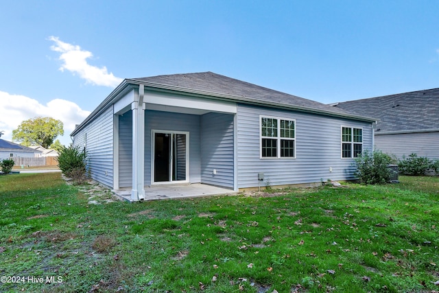 rear view of property with a patio and a lawn