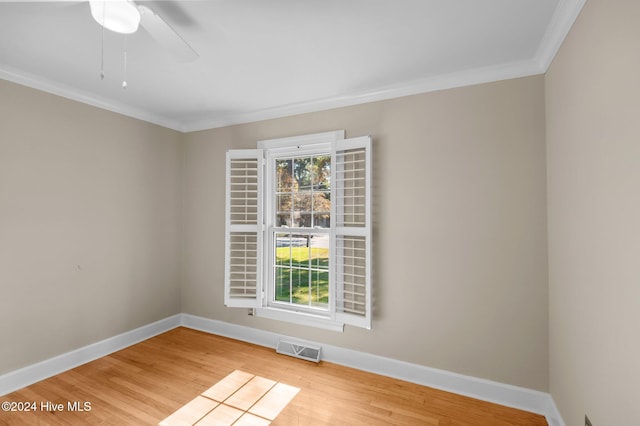 spare room with ornamental molding, light hardwood / wood-style flooring, and ceiling fan