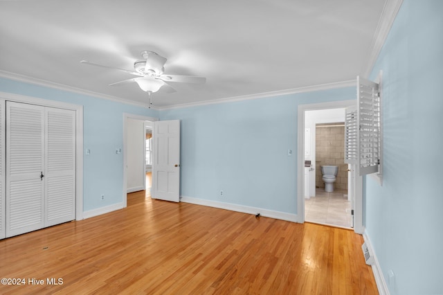 unfurnished bedroom with a closet, ornamental molding, connected bathroom, light hardwood / wood-style floors, and ceiling fan