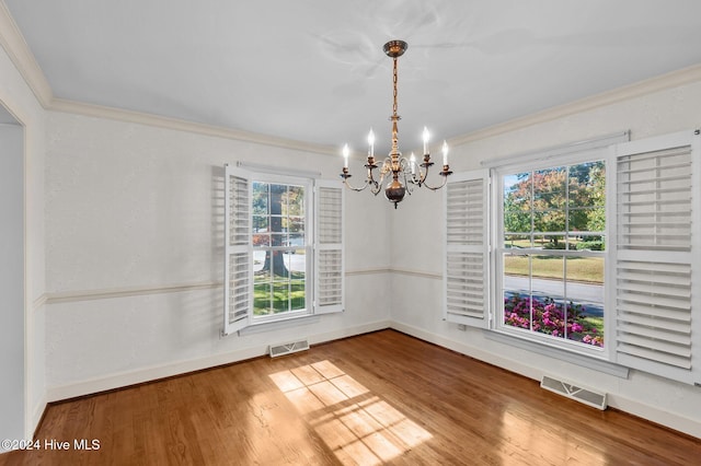 unfurnished dining area featuring a chandelier, hardwood / wood-style floors, and a healthy amount of sunlight