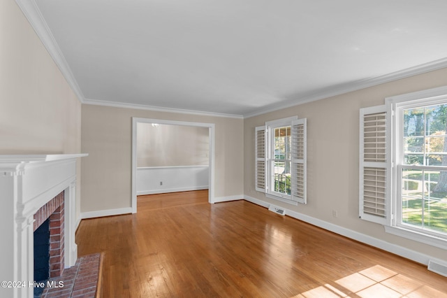 unfurnished living room featuring plenty of natural light, wood-type flooring, and crown molding