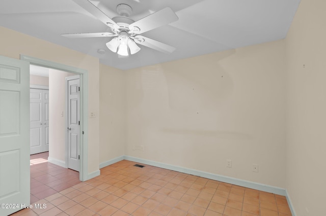 tiled empty room featuring ceiling fan