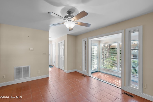 tiled spare room with ceiling fan