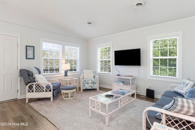 living room with hardwood / wood-style floors, vaulted ceiling, and ornamental molding