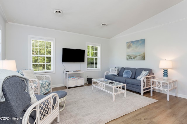 living room featuring hardwood / wood-style floors, crown molding, and vaulted ceiling