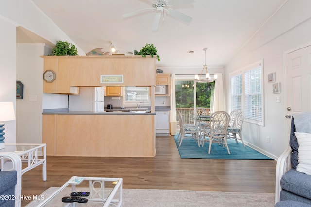 kitchen with light brown cabinets, white appliances, light wood-type flooring, and vaulted ceiling