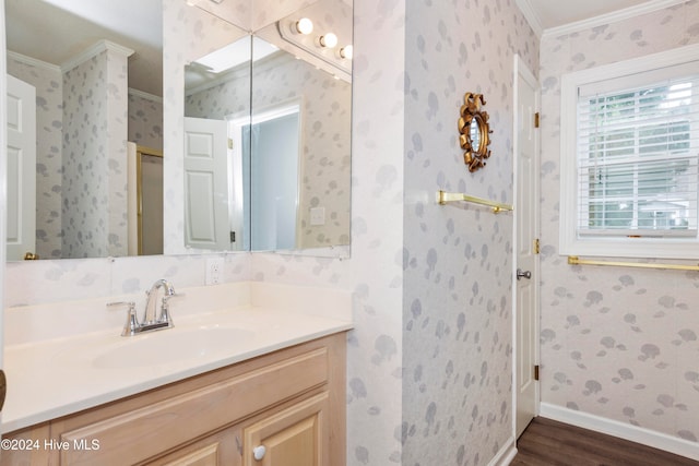 bathroom with hardwood / wood-style flooring, vanity, and crown molding