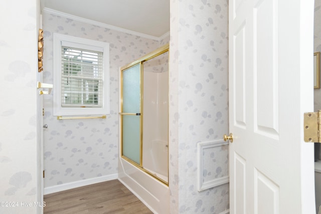 bathroom with wood-type flooring, crown molding, and enclosed tub / shower combo