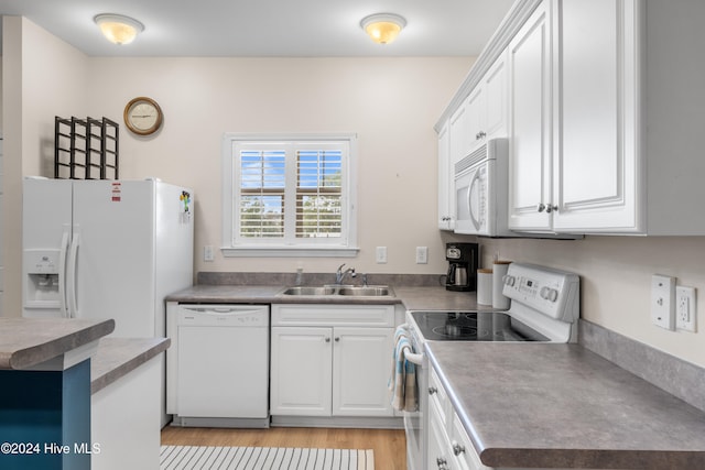 kitchen with sink, white cabinetry, light hardwood / wood-style flooring, and white appliances