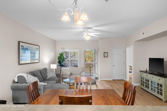 living room with light hardwood / wood-style flooring and ceiling fan with notable chandelier