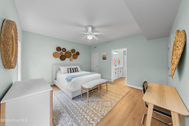 bedroom featuring ensuite bath, light hardwood / wood-style floors, and ceiling fan