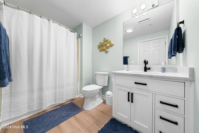 bathroom with vanity, curtained shower, hardwood / wood-style flooring, and toilet