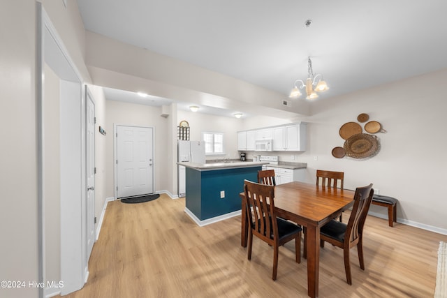 dining area featuring light hardwood / wood-style flooring and a chandelier