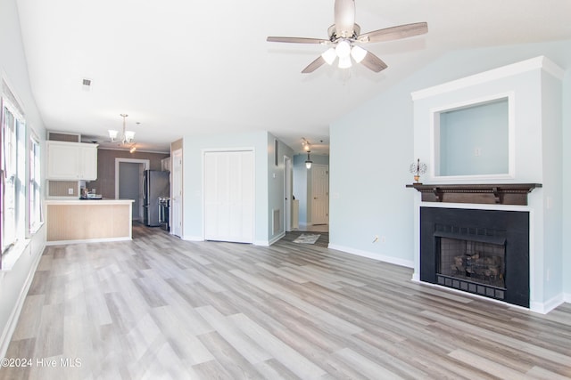 unfurnished living room with ceiling fan, lofted ceiling, and light wood-type flooring