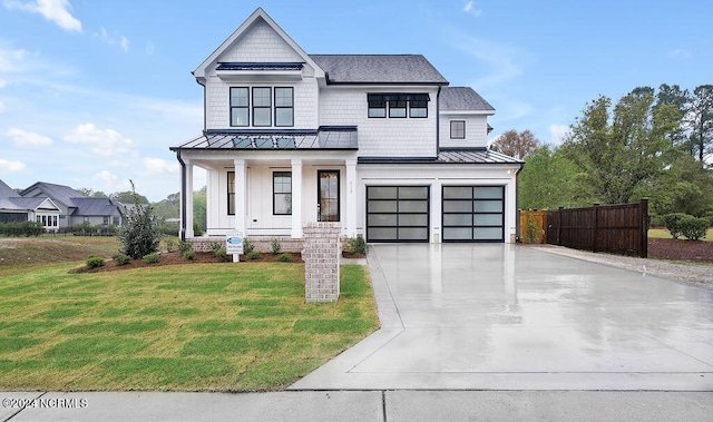 modern inspired farmhouse featuring covered porch, a front lawn, and a garage